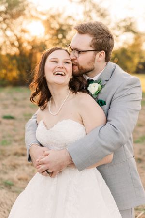 Joyful wedding moment captured during sunset as couple shares intimate laughter.