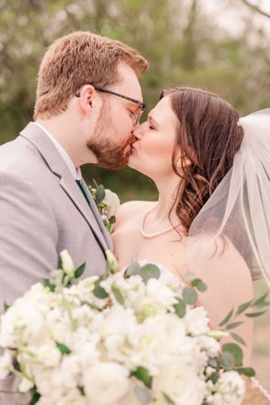 Romantic wedding portrait with white bouquet and soft natural lighting.