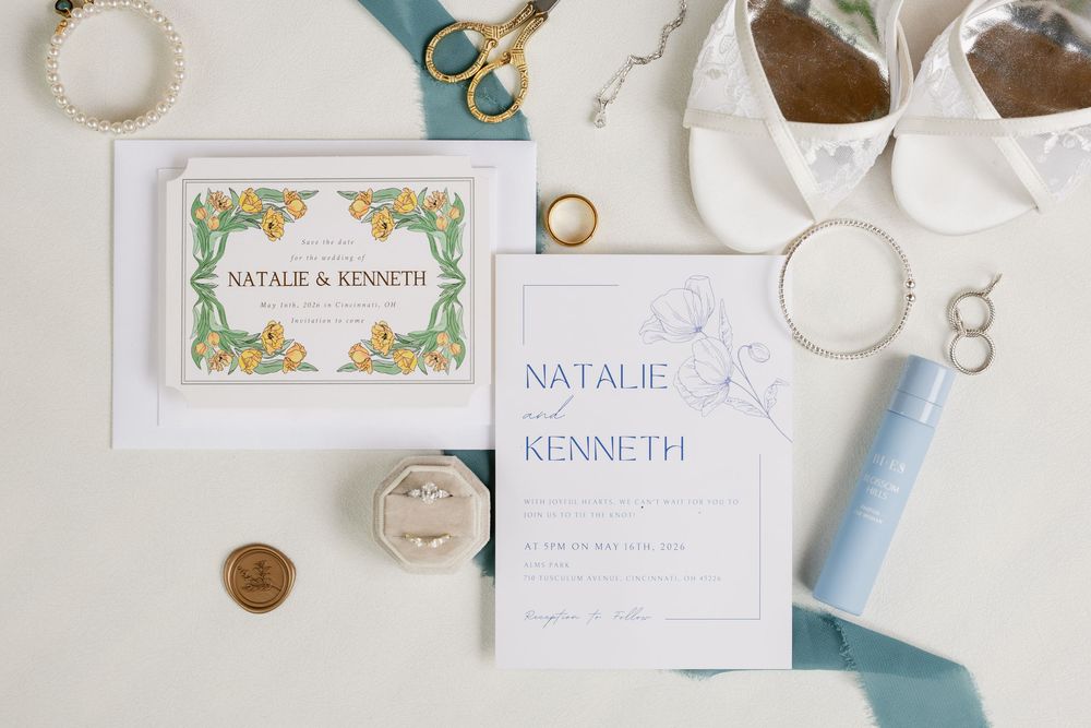 Elegant wedding invitation suite for Natalie and Kenneth with blue ribbon, gold scissors, rings, and floral details on white background.