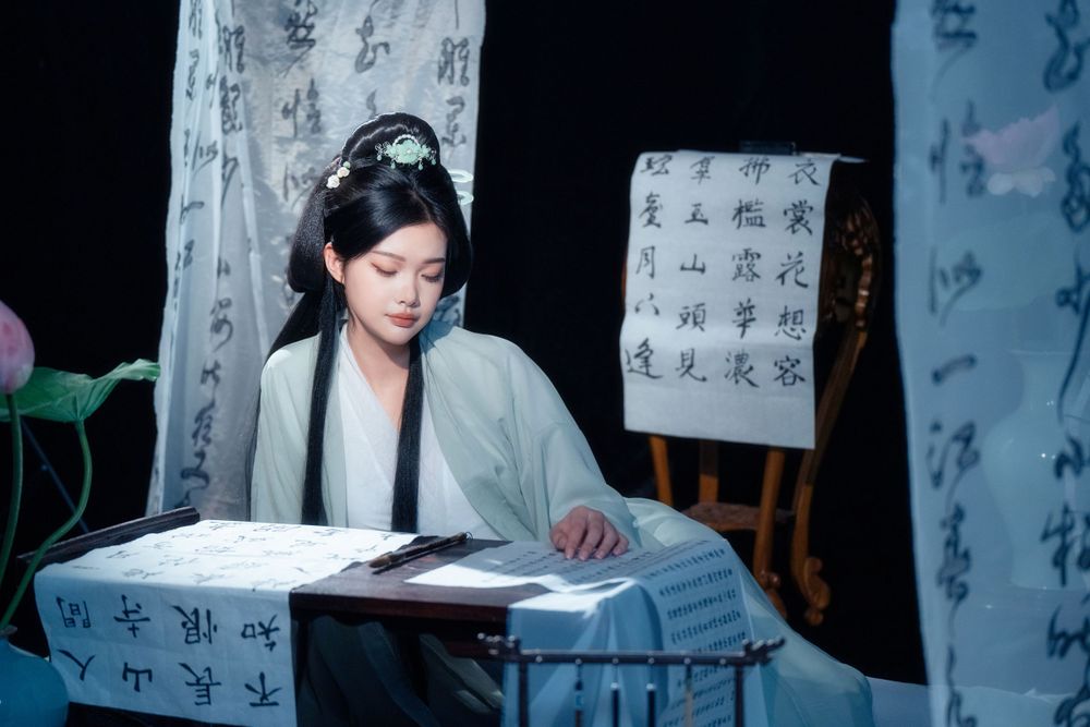 Elegant solo Hanfu portrait of a woman writing calligraphy among traditional script banners, by Imagine Image Studio.