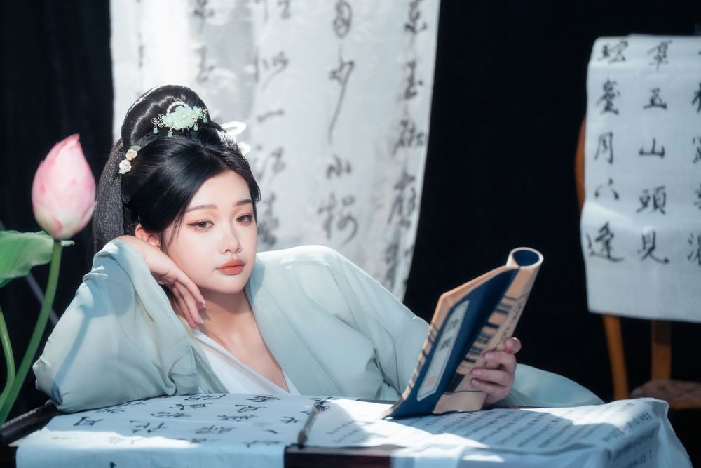 Elegant solo Hanfu portrait of a woman writing calligraphy among traditional script banners, by Imagine Image Studio.