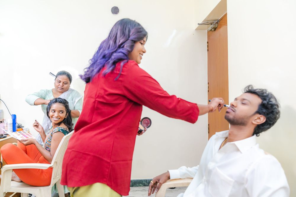 Behind-the-scenes photo of a makeup session with people watching in the background.