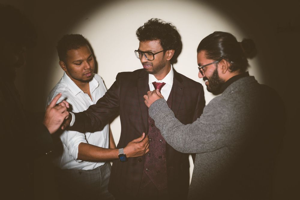 Three people in formal attire having an animated discussion under dramatic spotlight.