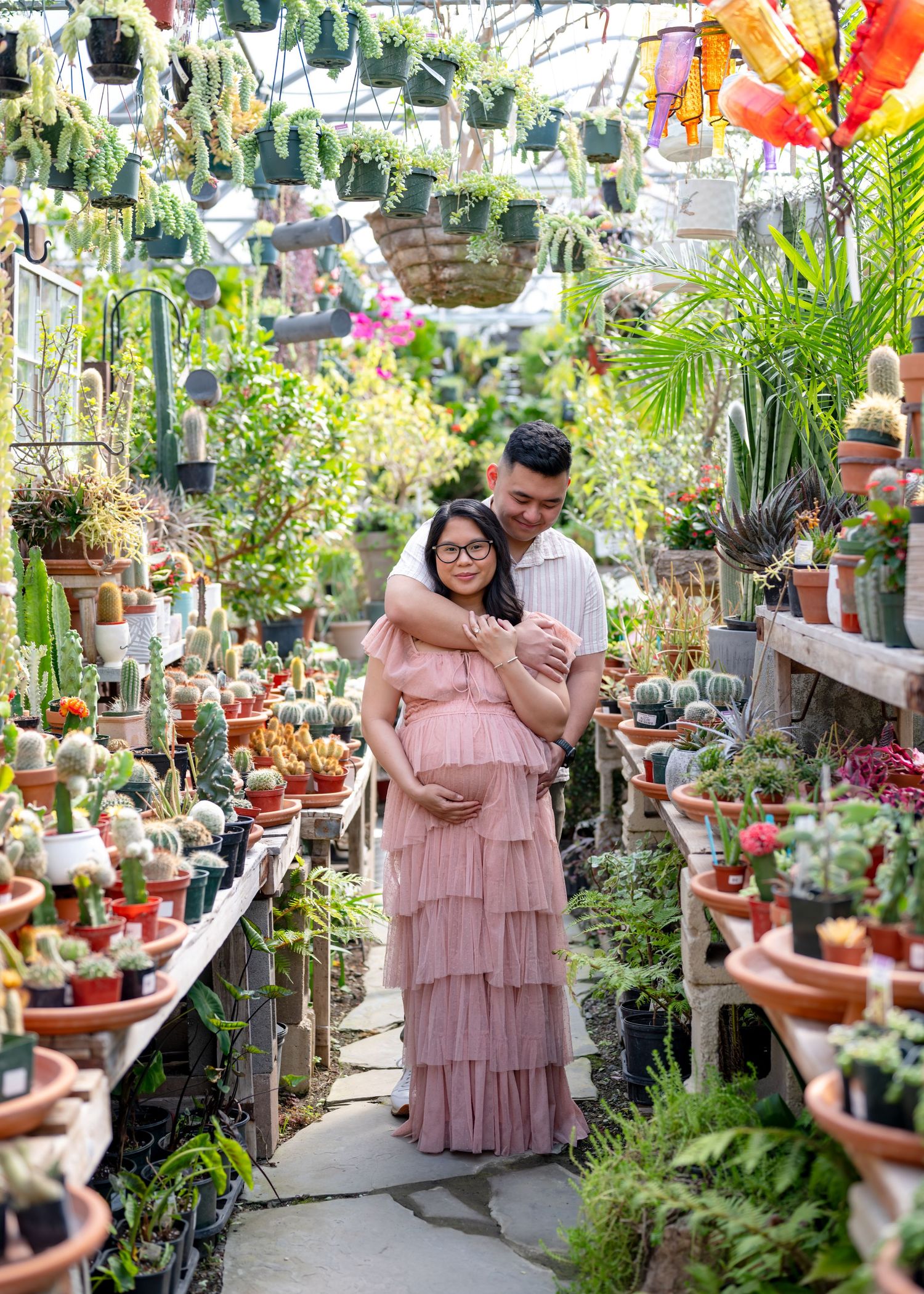 Maternity session of mom and dad embracing in a greenhouse setting. Wrightstown NJ Maternity Photographer