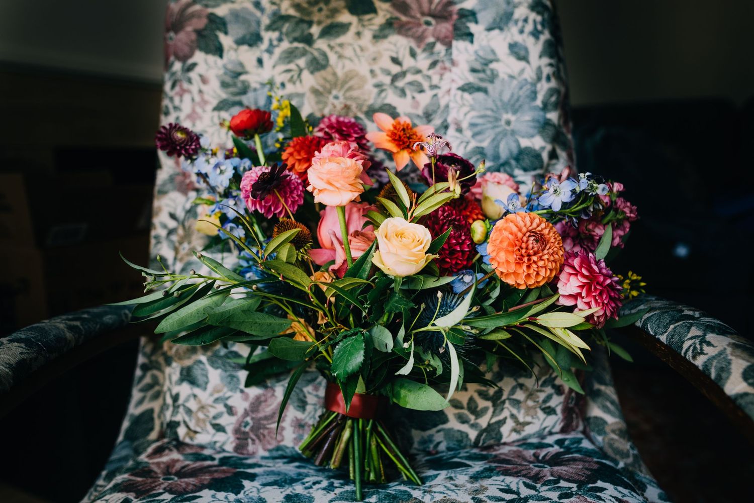 Perfect vibrant bouquet filled with pink dahlias, red and orange roses, tulips. All sorts of blues, greens, and yellows