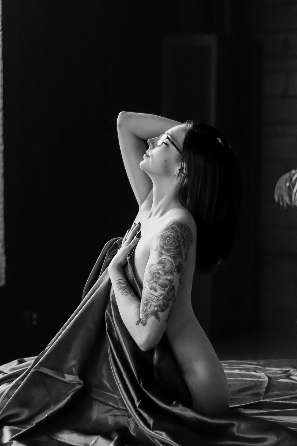 Artistic black and white portrait of person wrapped in flowing fabric.