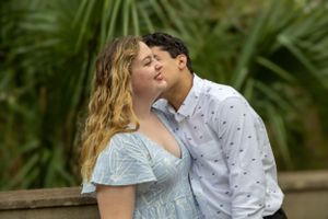 Romantic moment shared between a couple in pastel outfits against tropical foliage. University of Central Florida
