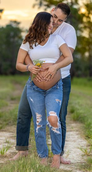 Romantic maternity photo of couple embracing on nature path at sunset. Geneva, Florida