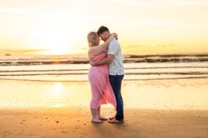 A romantic beach sunset photo with couple embracing on golden sand. Cape Canaveral, Florida