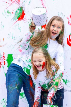 Two people laughing while covered in colorful paint during fun photo session. Orlando, Florida