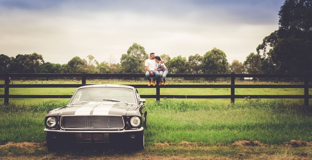 Pre Wedding shoot of a Sri Lankan Tamil couple sitting on a fence in front of their classic mustang in Sydney