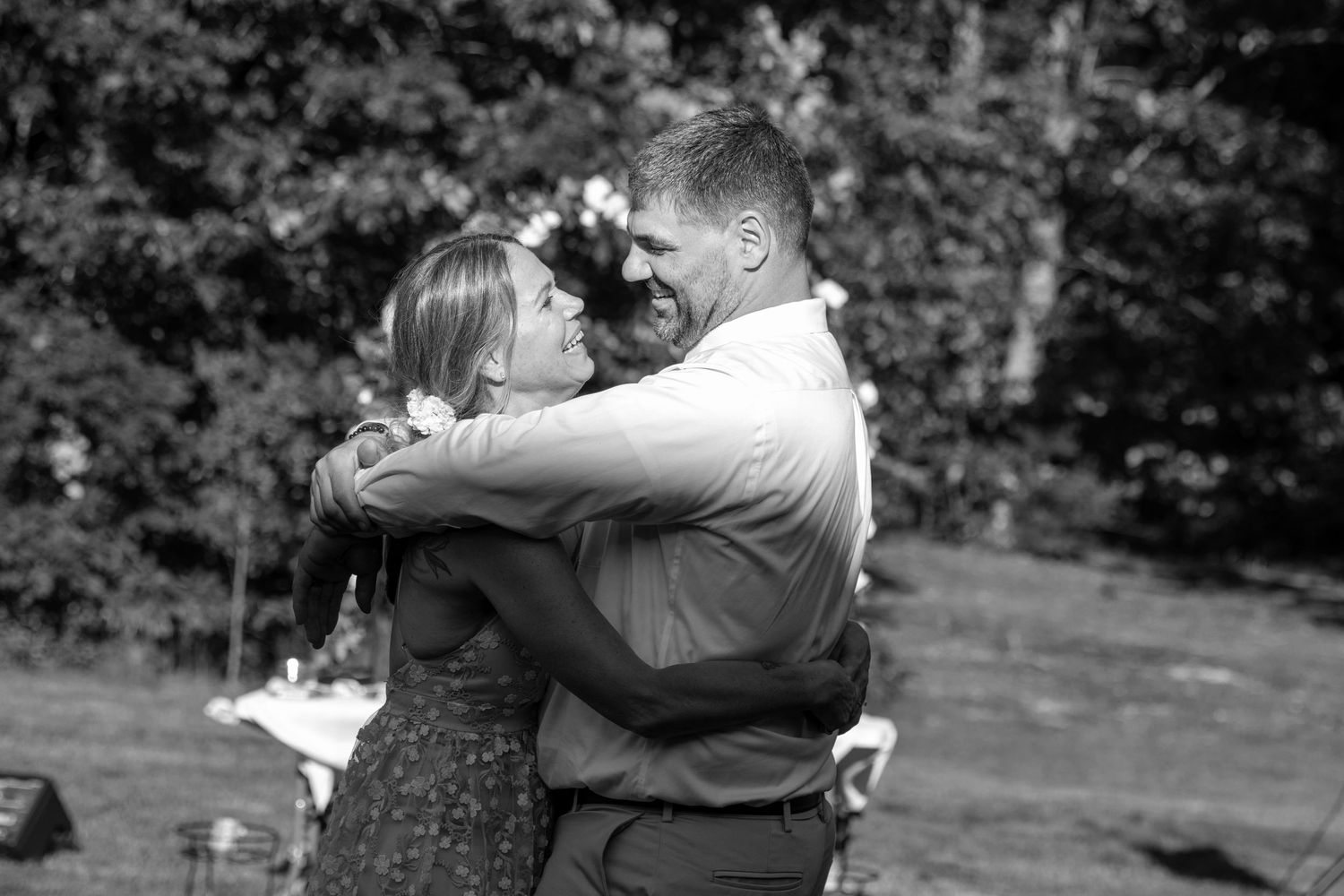 A bride and groom laugh together during their first dance.