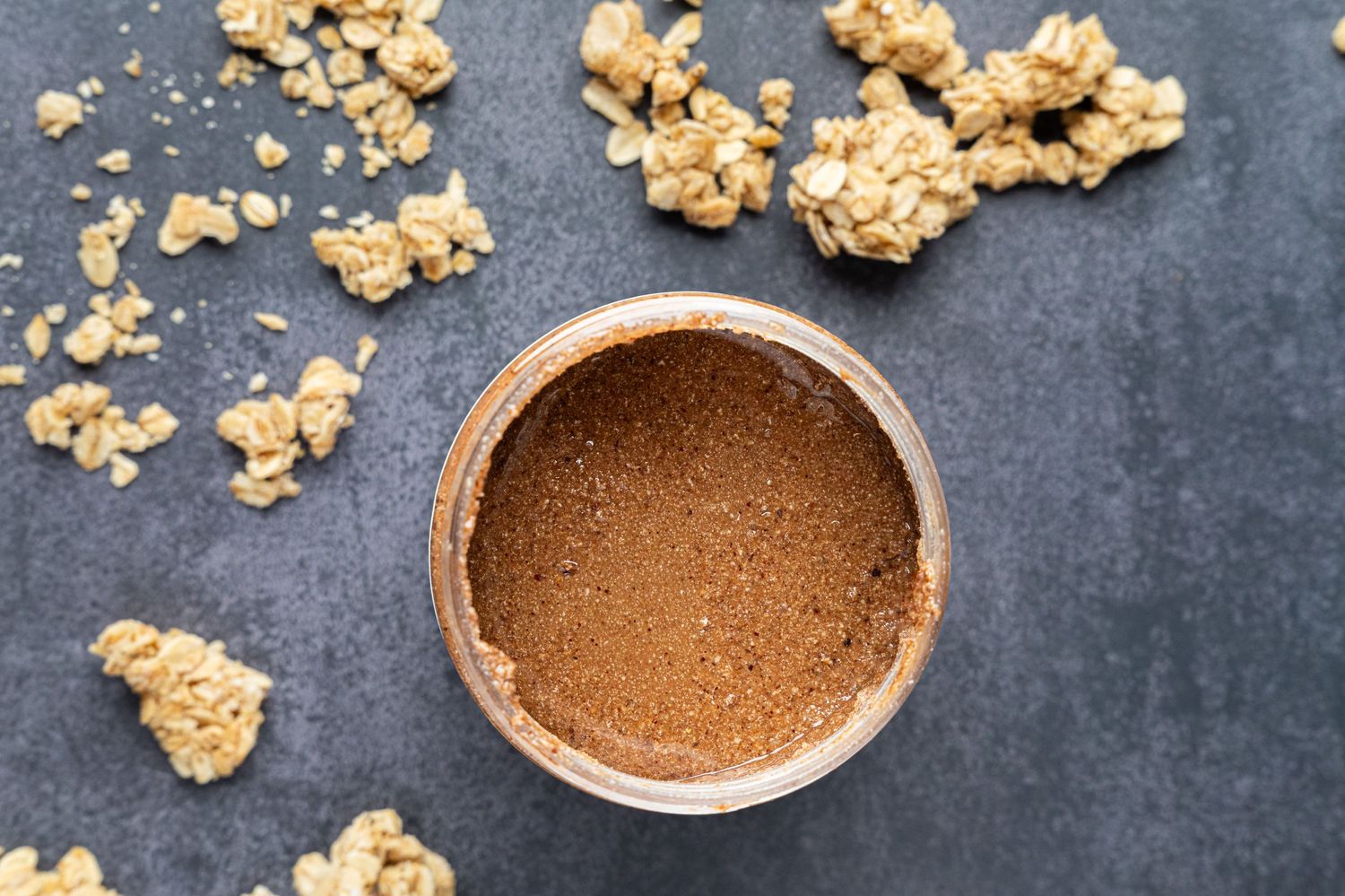 Homemade chocolate peanut butter popcorn balls scattered on a dark textured surface with cocoa powder.