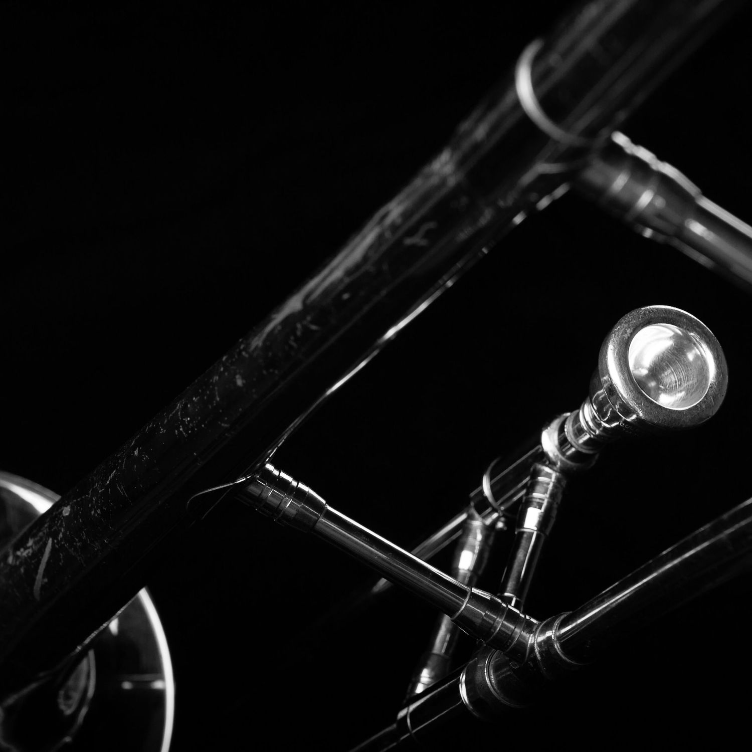 Detail of a trombone mouthpiece and bell in black and white