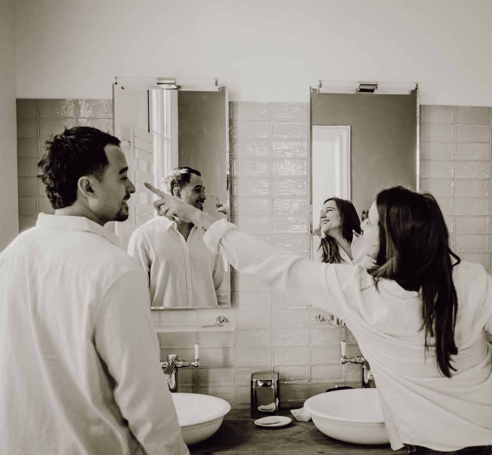 Candid black and white photo of a couple getting ready in their bathroom. photographe futur maman Bordeaux, Gironde