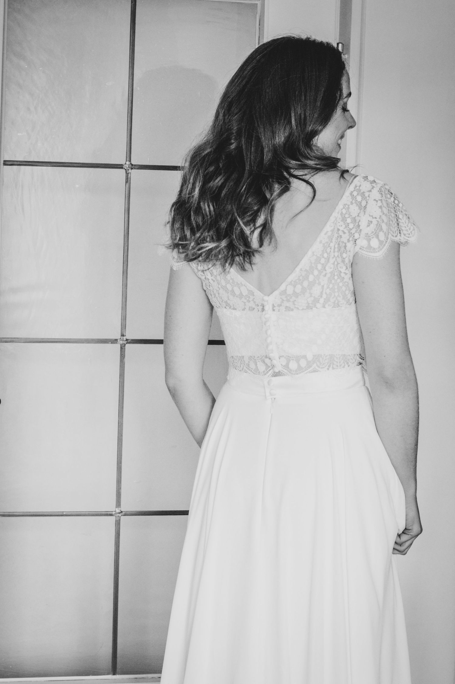 Eine Braut steht in ihrem Zweiteiler-Brautkleid von Kleider machen Bräute in der Tür.