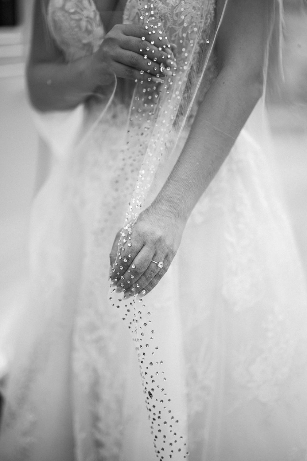 Close-up of sparkly beading detail on wedding dress in black and white.