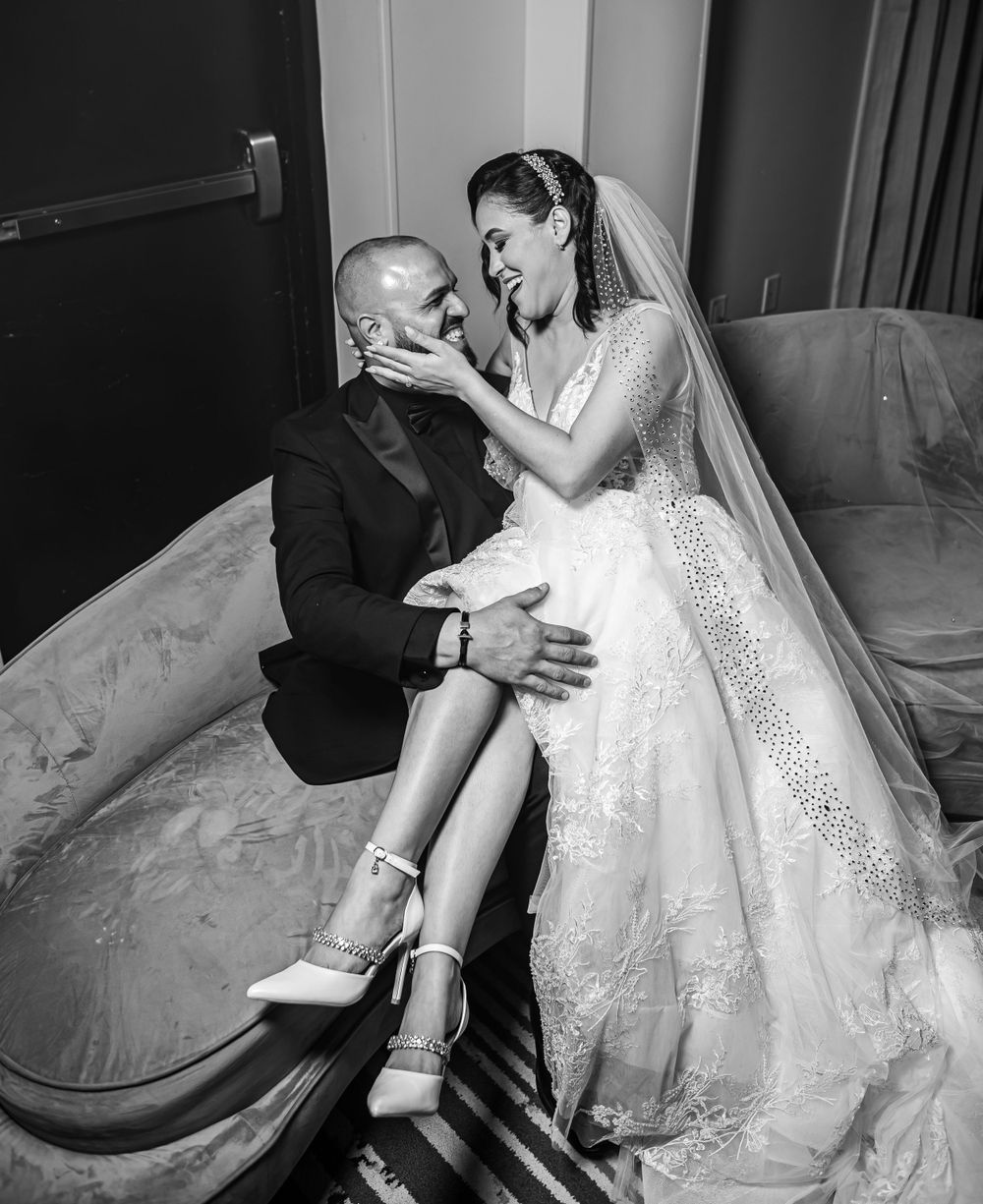 An intimate black and white portrait captures a tender moment between newlyweds on their wedding day.