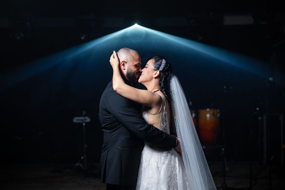 A dramatic wedding dance photo with blue lighting highlights the couple's first dance moment.