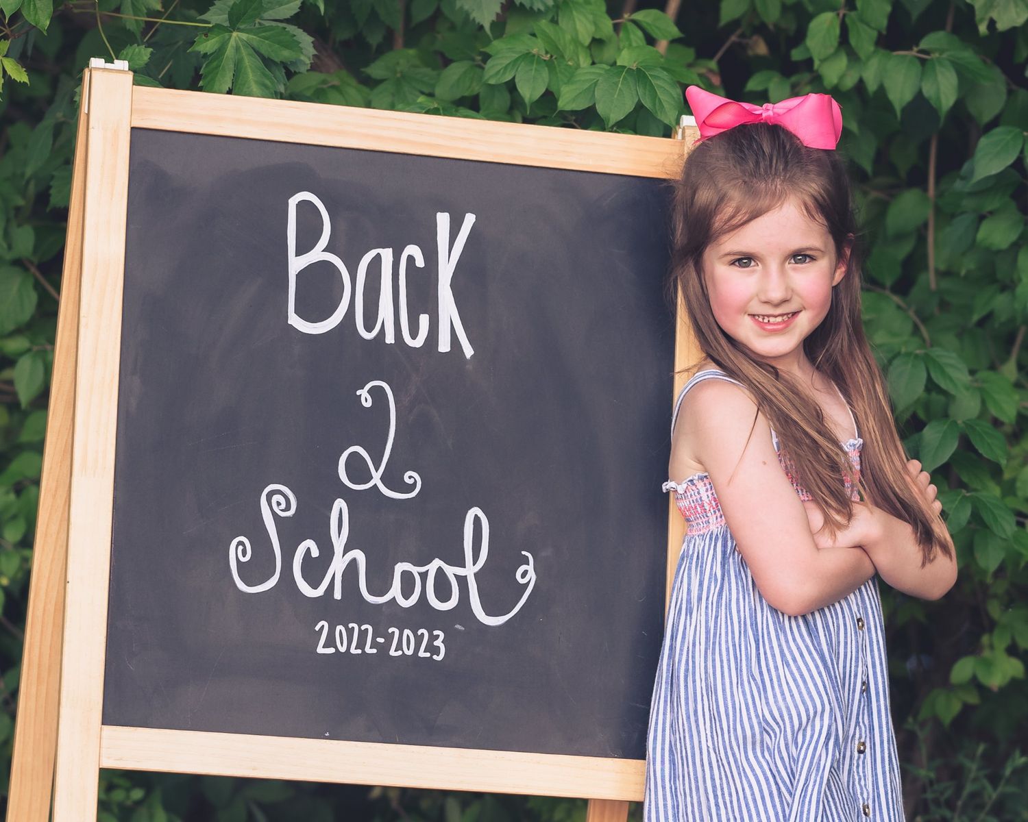 A back-to-school themed photo series with chalkboard signs and blue striped dress.