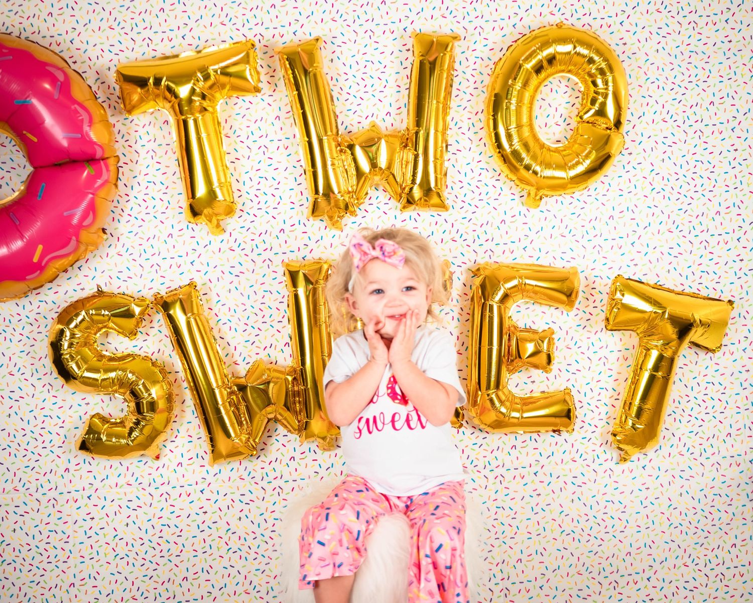 Gold balloon letters spelling TWO SWEET against a polka dot backdrop.