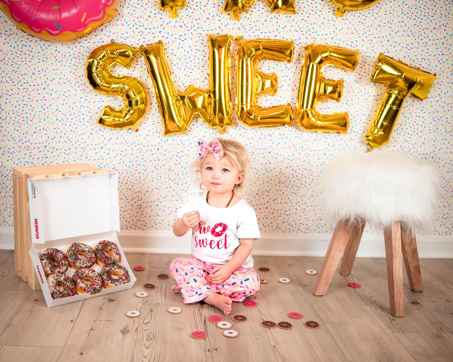 TWO SWEET party setup with gold balloons and pink donut decorations.