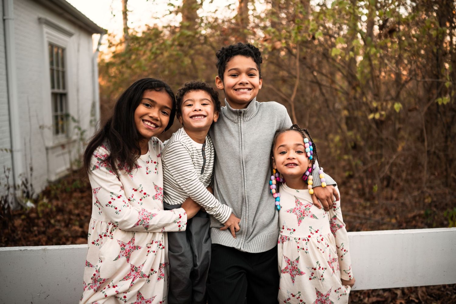 A family shares joyful moments together outdoors during a golden sunset photo session.