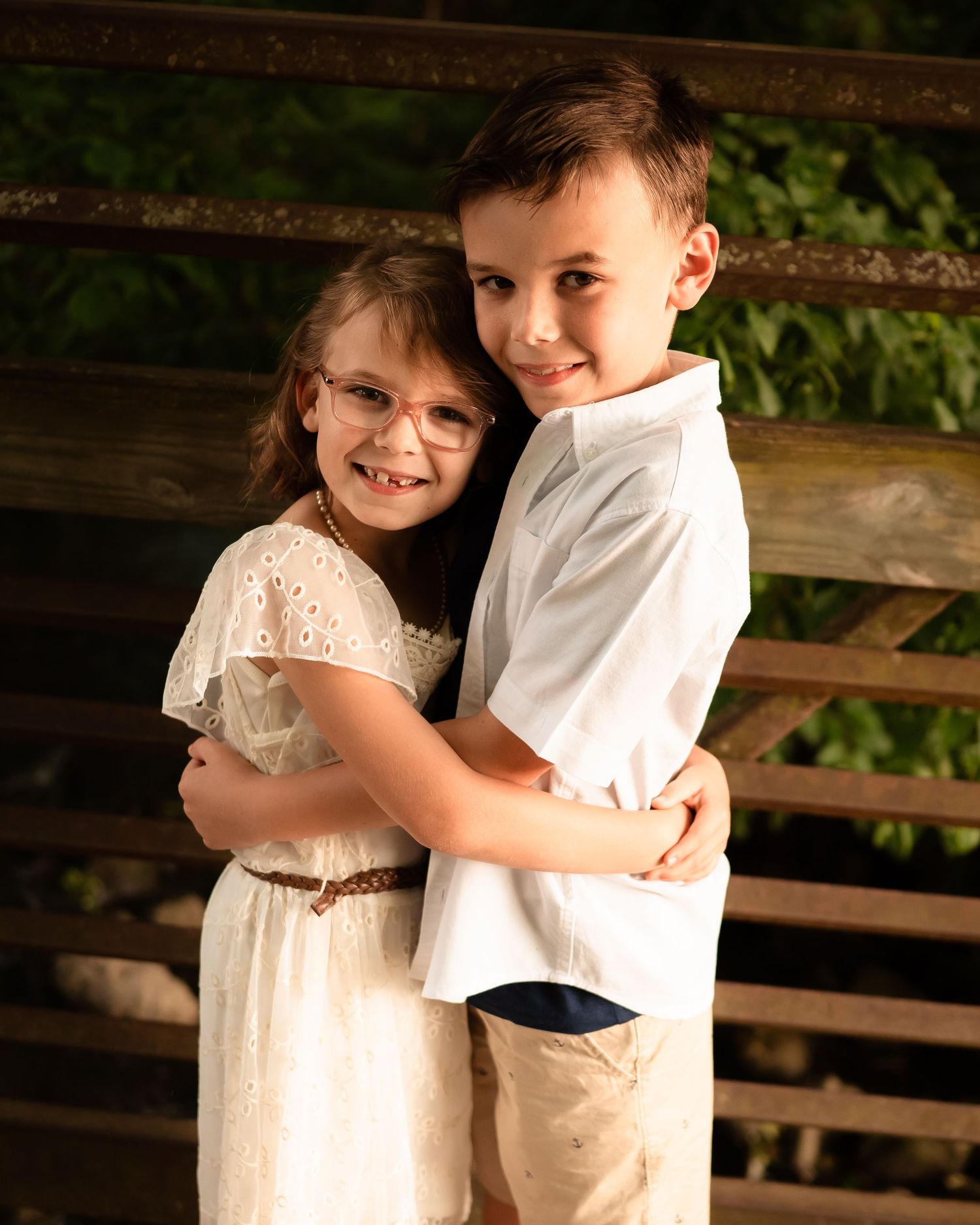 Sweet embrace on wooden bridge during golden hour photo session.