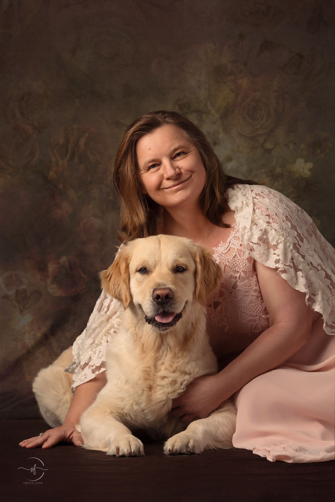 A Golden Retriever and companion pose for a formal portrait against a textured brown backdrop.