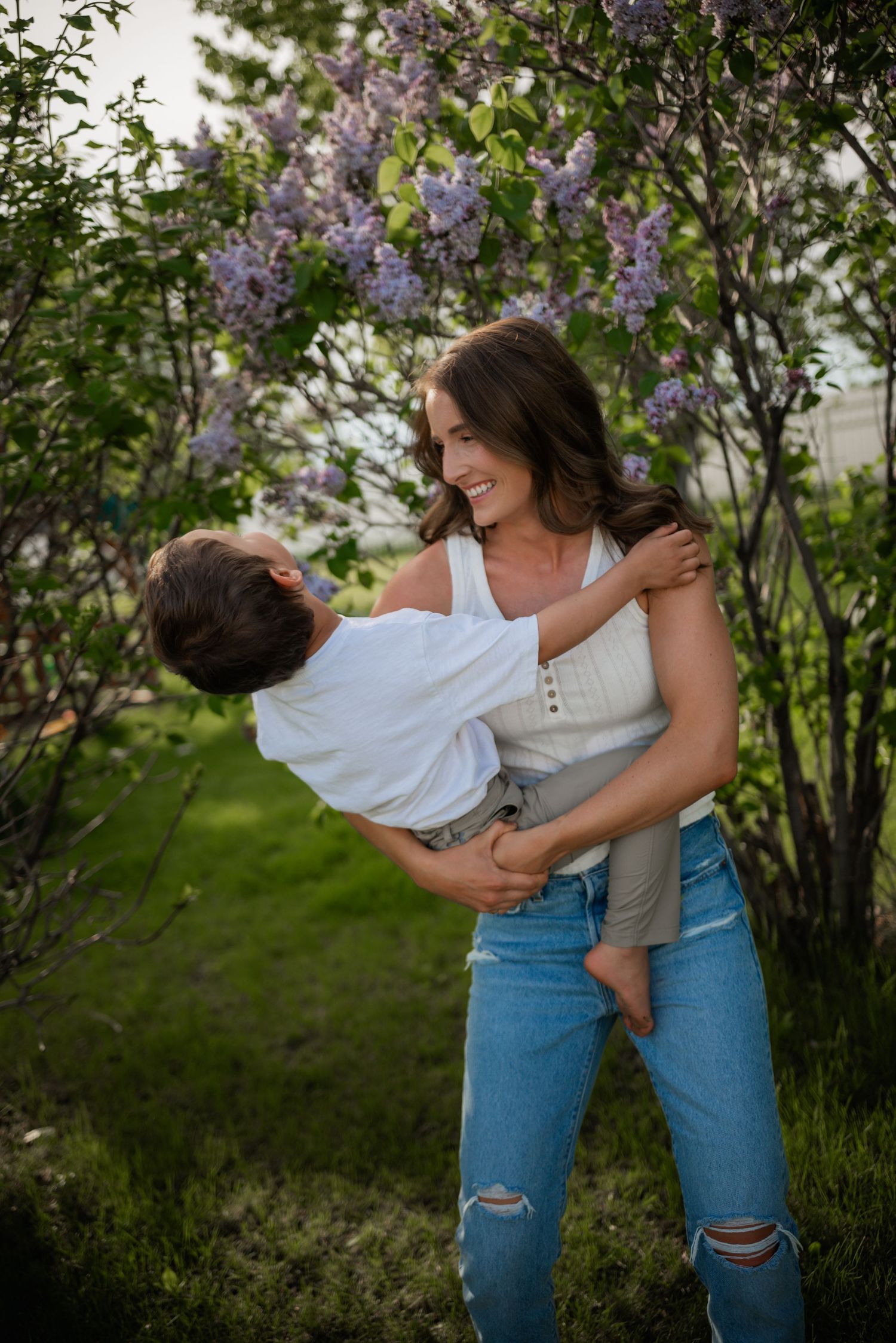 A playful moment captured near blooming lilac bushes in springtime.