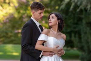 A romantic couple embraces during their outdoor wedding photoshoot in a lush garden setting.