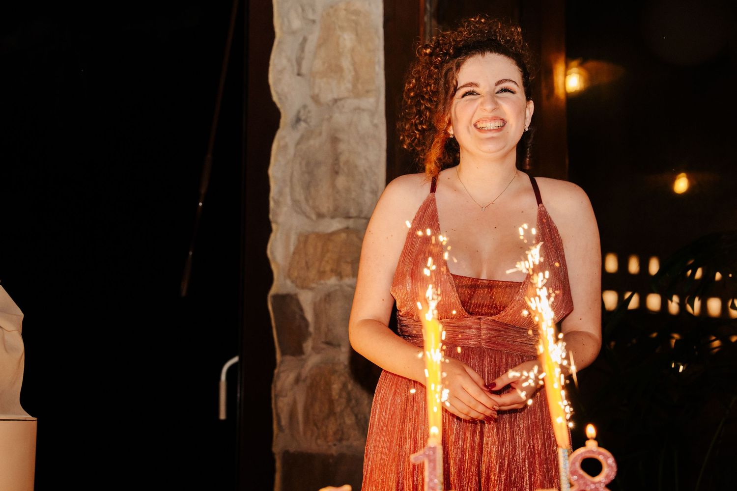 Ragazza giovane che festeggia il suo diciottesimo compleanno alle scuderie di coco a Sarzana in Liguria con la torta e le candeline