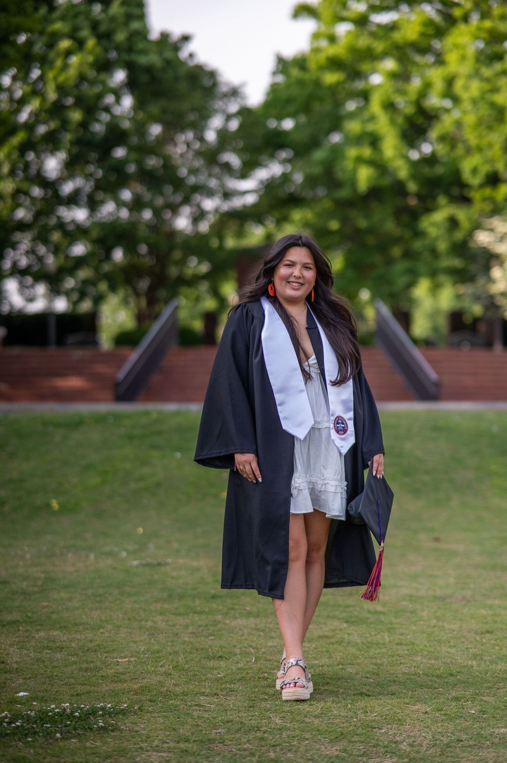 Clemson Graduate in gown holding cap, Clemson, South Carolina.