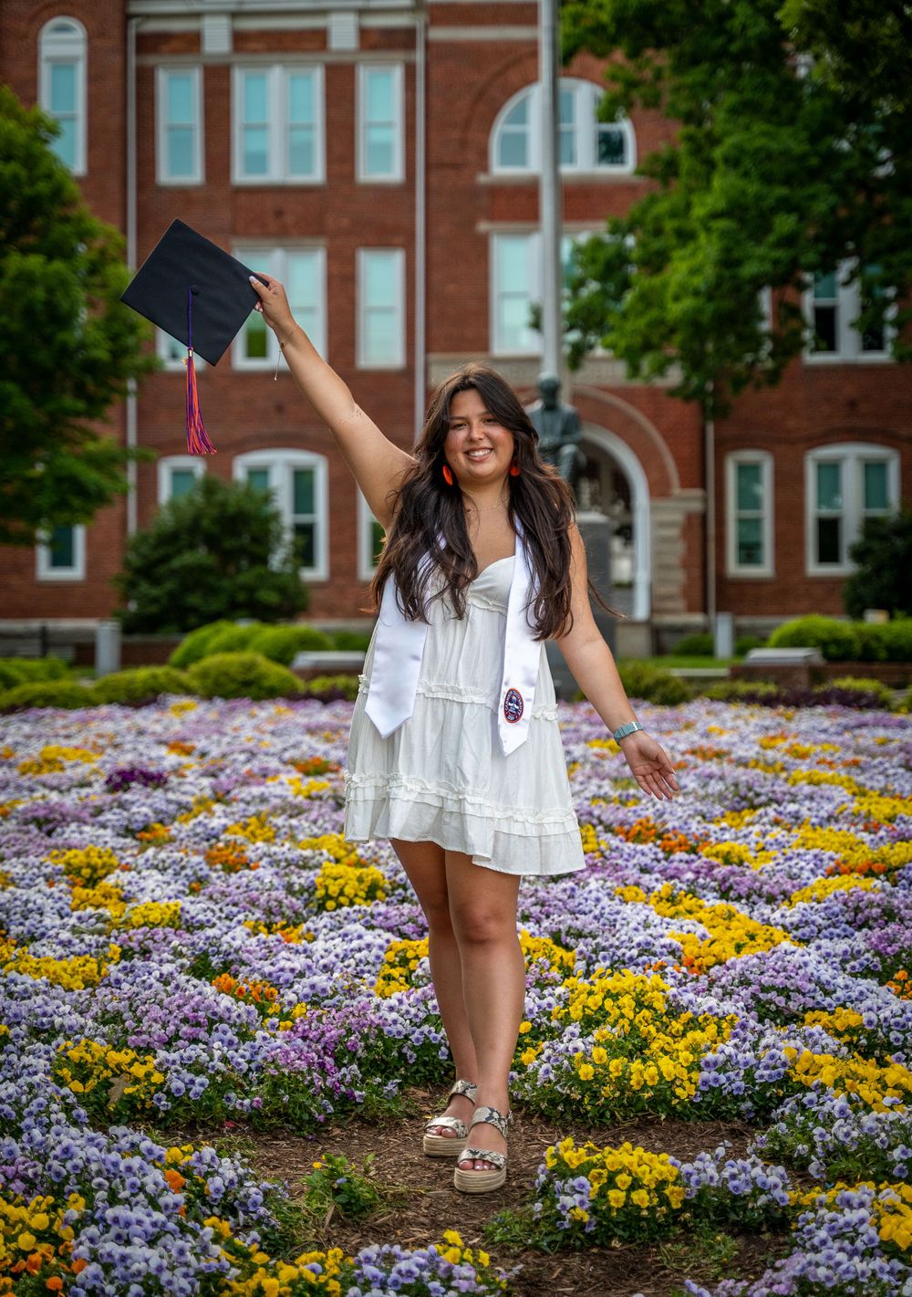 Clemson graduate holding cap at Gannt Circle with Tillman Hall in background, Clemson, South Carolina
