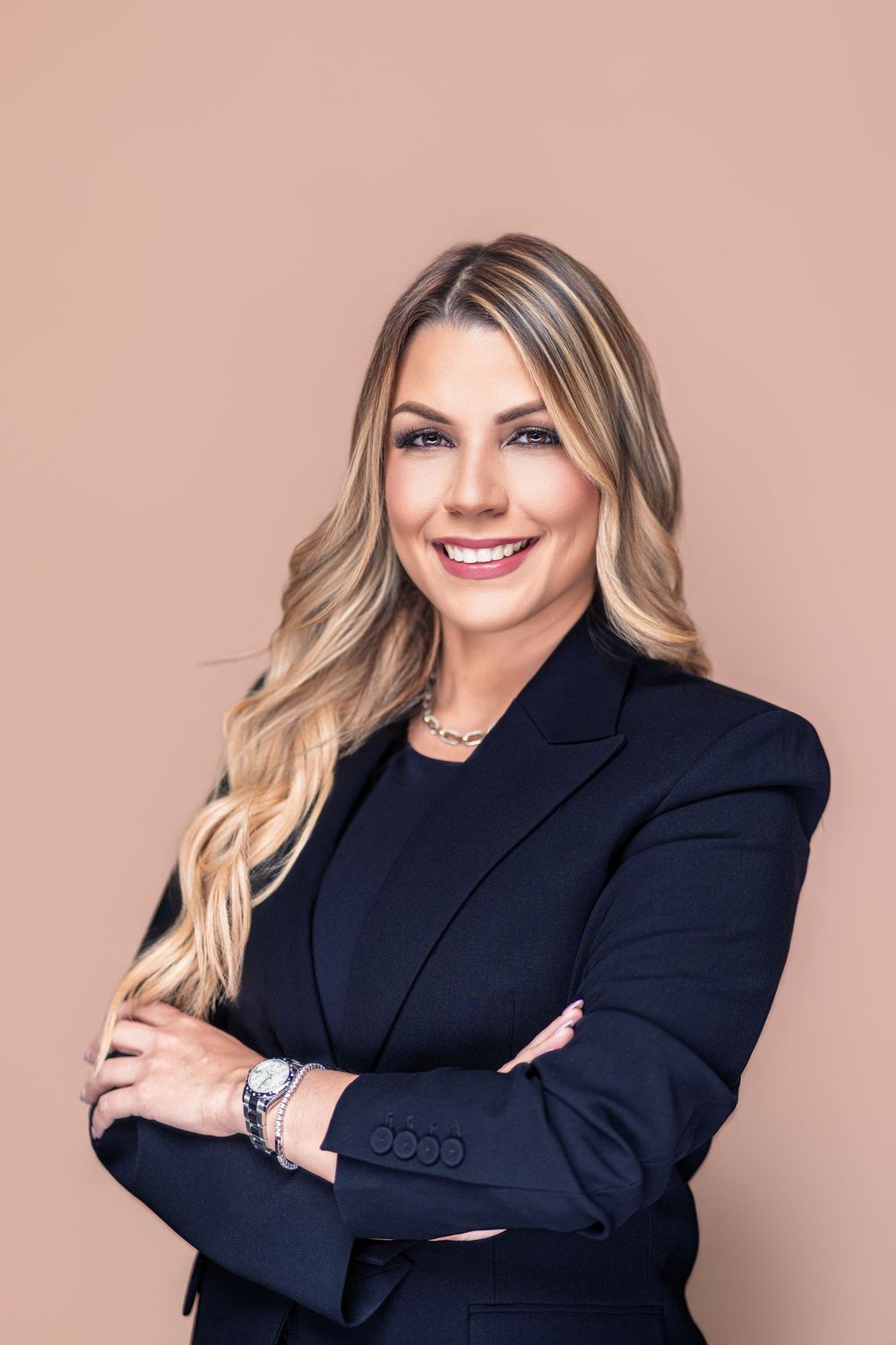 Professional business portrait series showing person in black blazer against neutral pink background with confident poses.