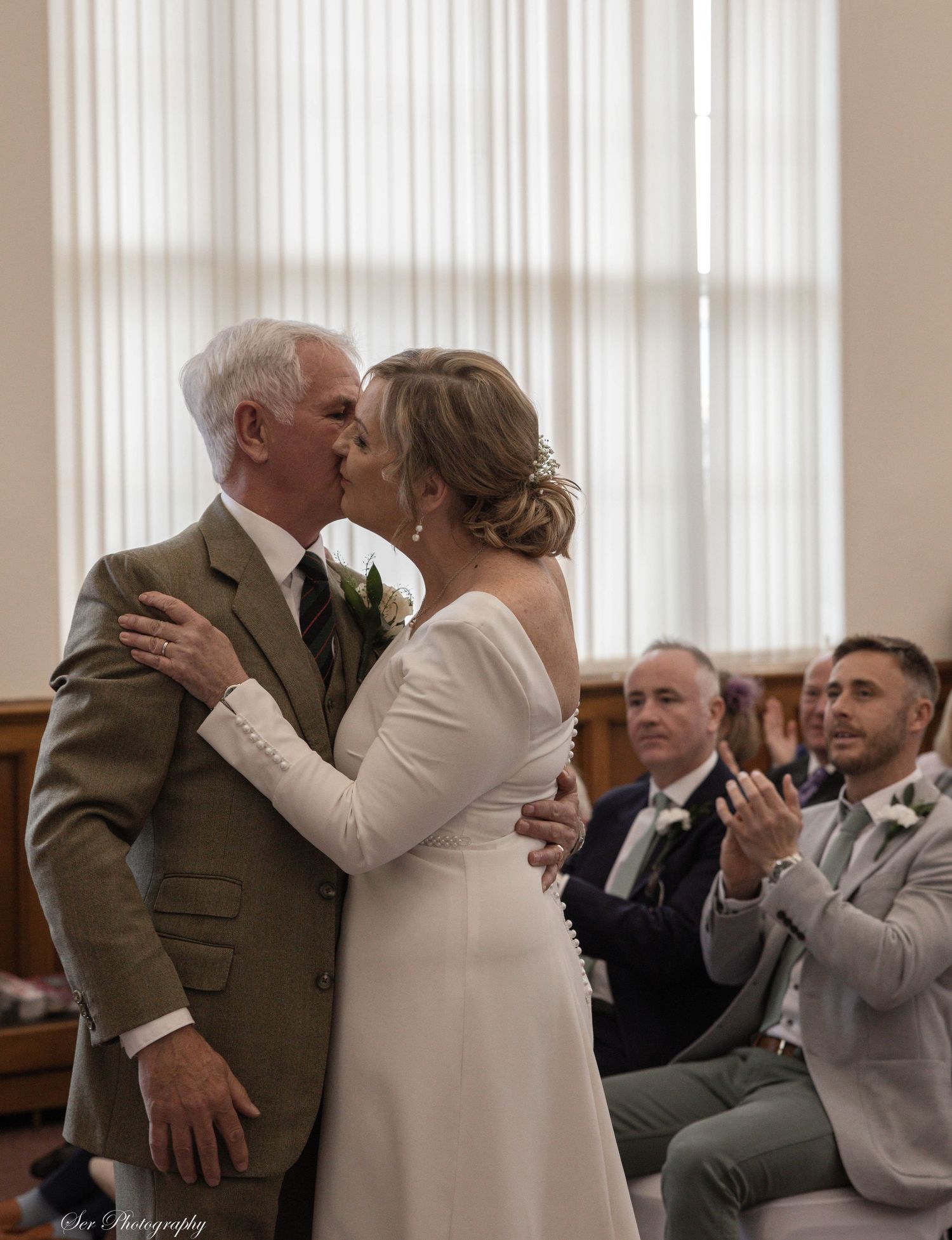 Bride and groom kissing at wedding