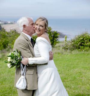 Bride and groom embrace on the cliffs