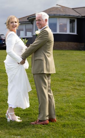 Bride and groom hold hands looking back
