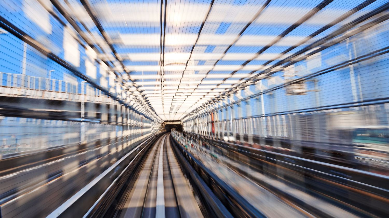 Dynamic view through illuminated tunnel with motion blur effect and converging lines.