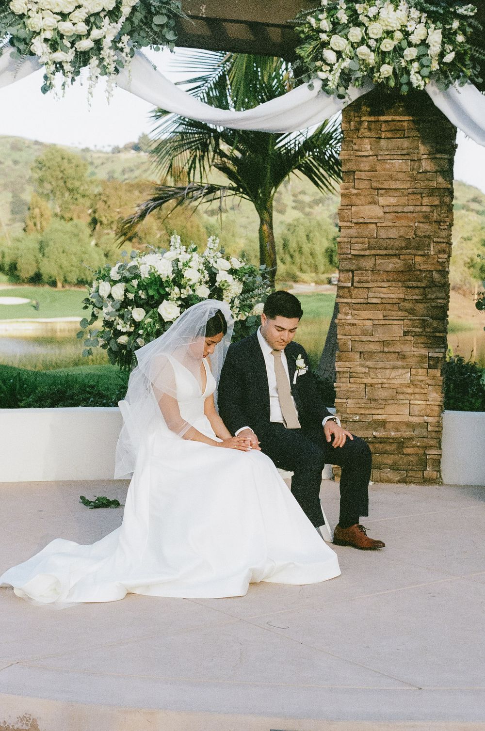 Wedding couple shares intimate moments during their photo session at an elegant outdoor venue.