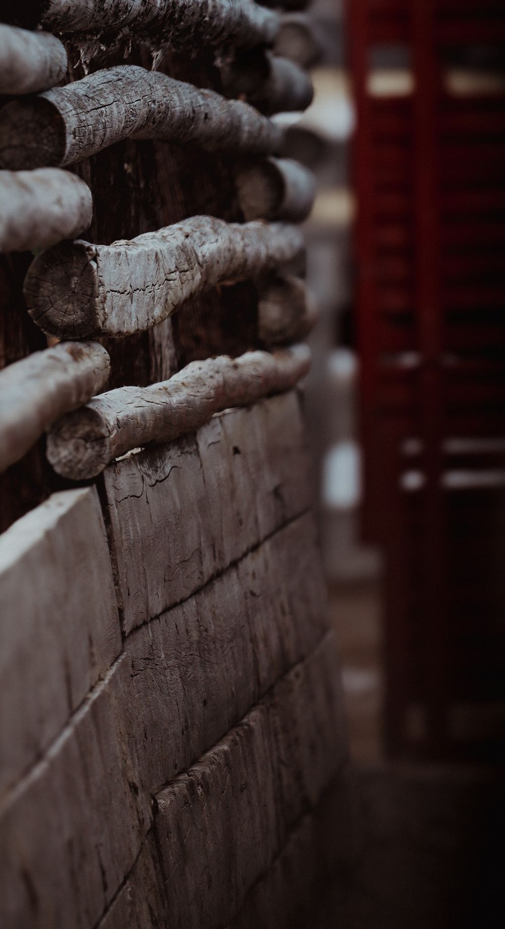 Close-up detail of stacked wooden logs in a traditional log fence construction.