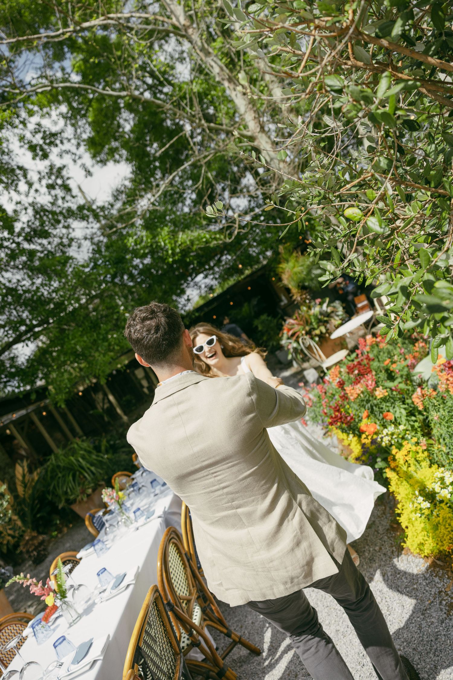A wedding ceremony taking place under a majestic oak tree in black and white.