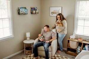 Intimate indoor maternity photo session showing tender moments in a nursery setting.