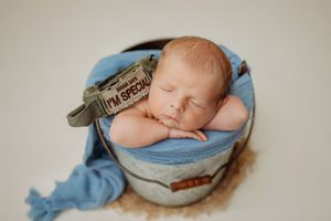 Artistic newborn photography series with soft blue tones and minimalist styling.