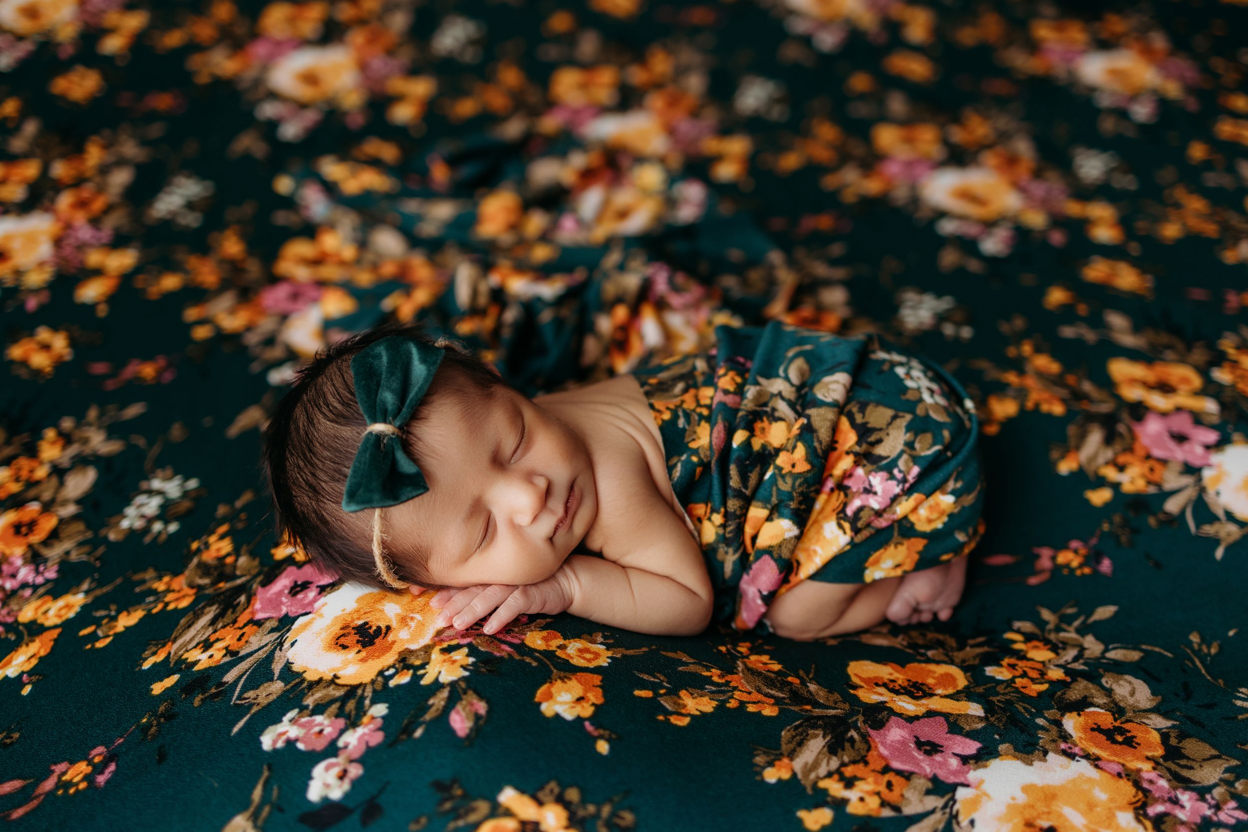 Colorful autumn leaves scattered around a person lying on dark ground creating an artistic fall portrait scene.