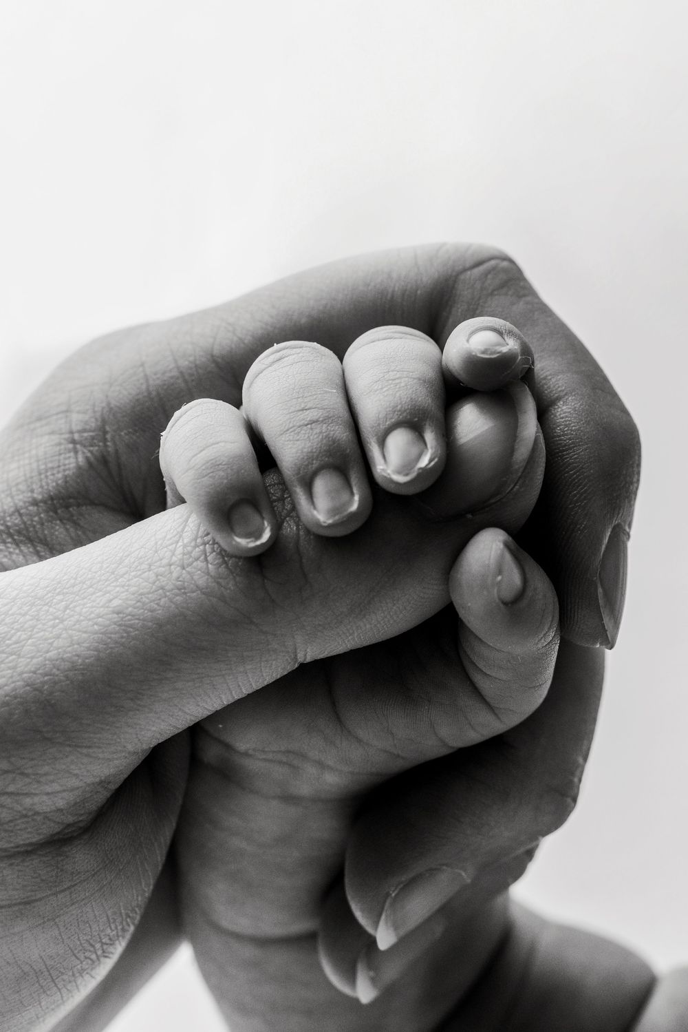 Black and white artistic photo series showing close-up shots of hands holding and grasping each other in different poses.