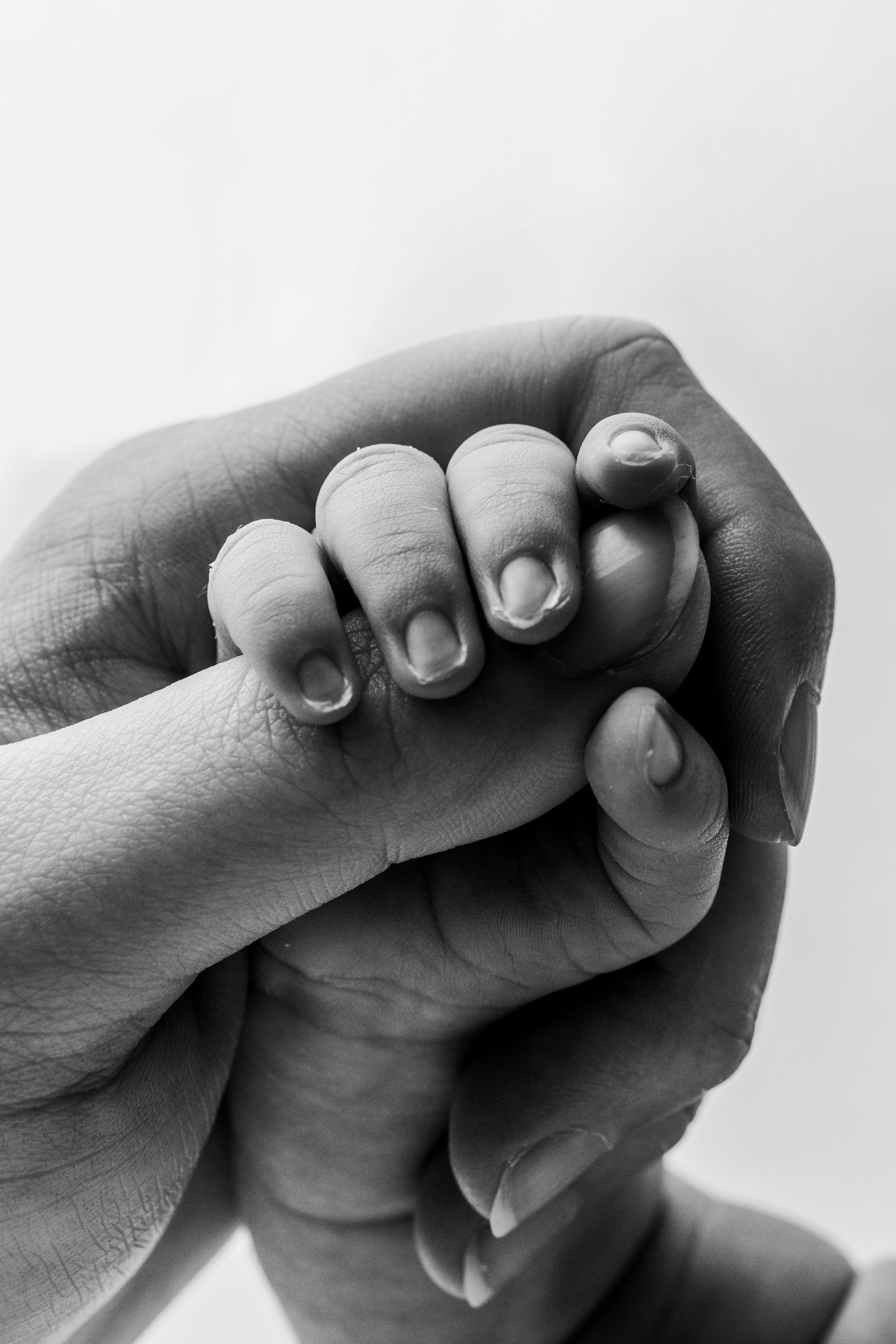 Black and white artistic photo series showing close-up shots of hands holding and grasping each other in different poses.