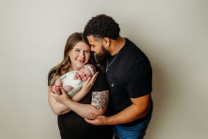 Intimate family portrait series with newborn against light grey backdrop.