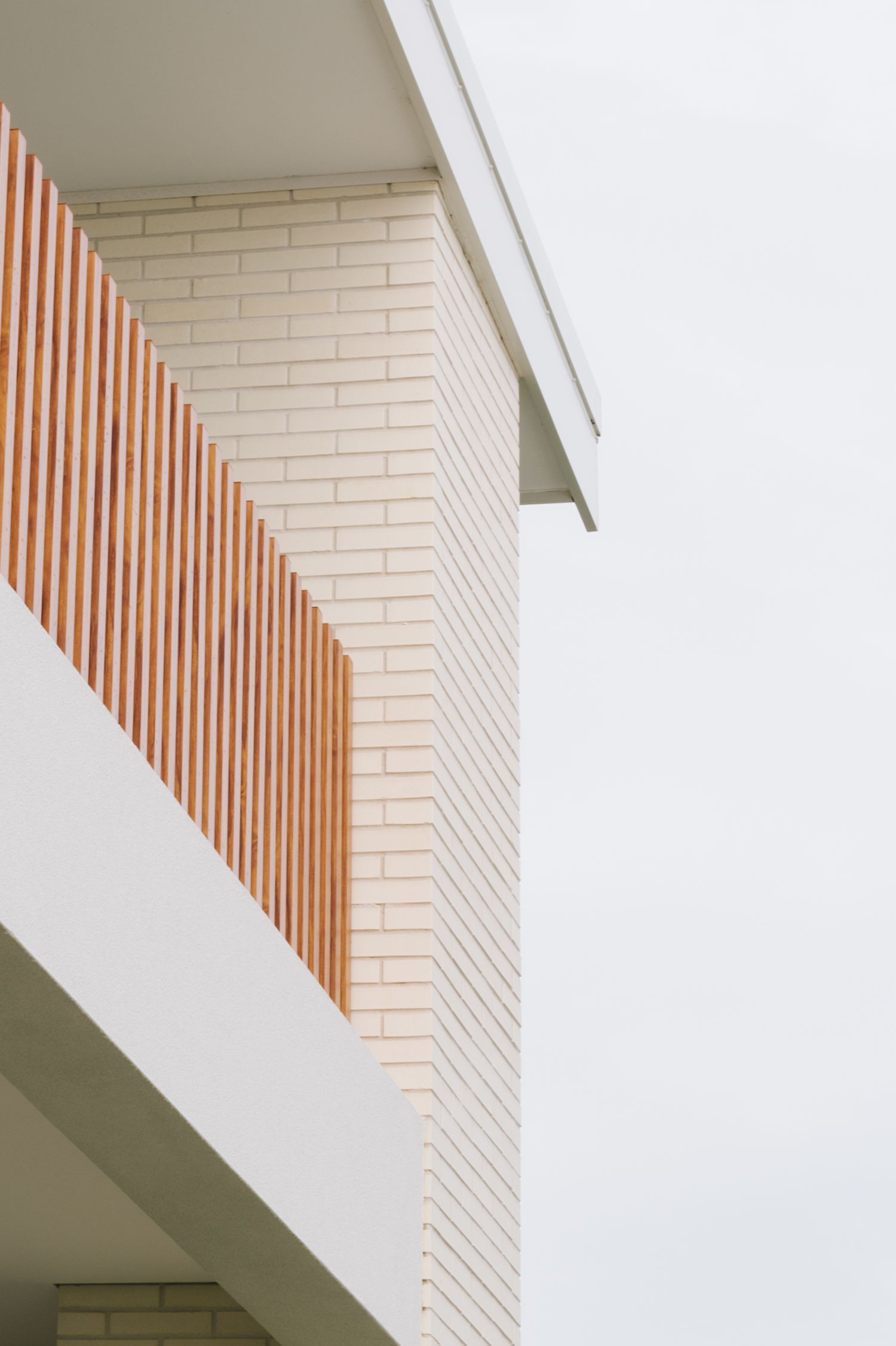 Modern architectural detail showing white brick wall with wooden slat accent.