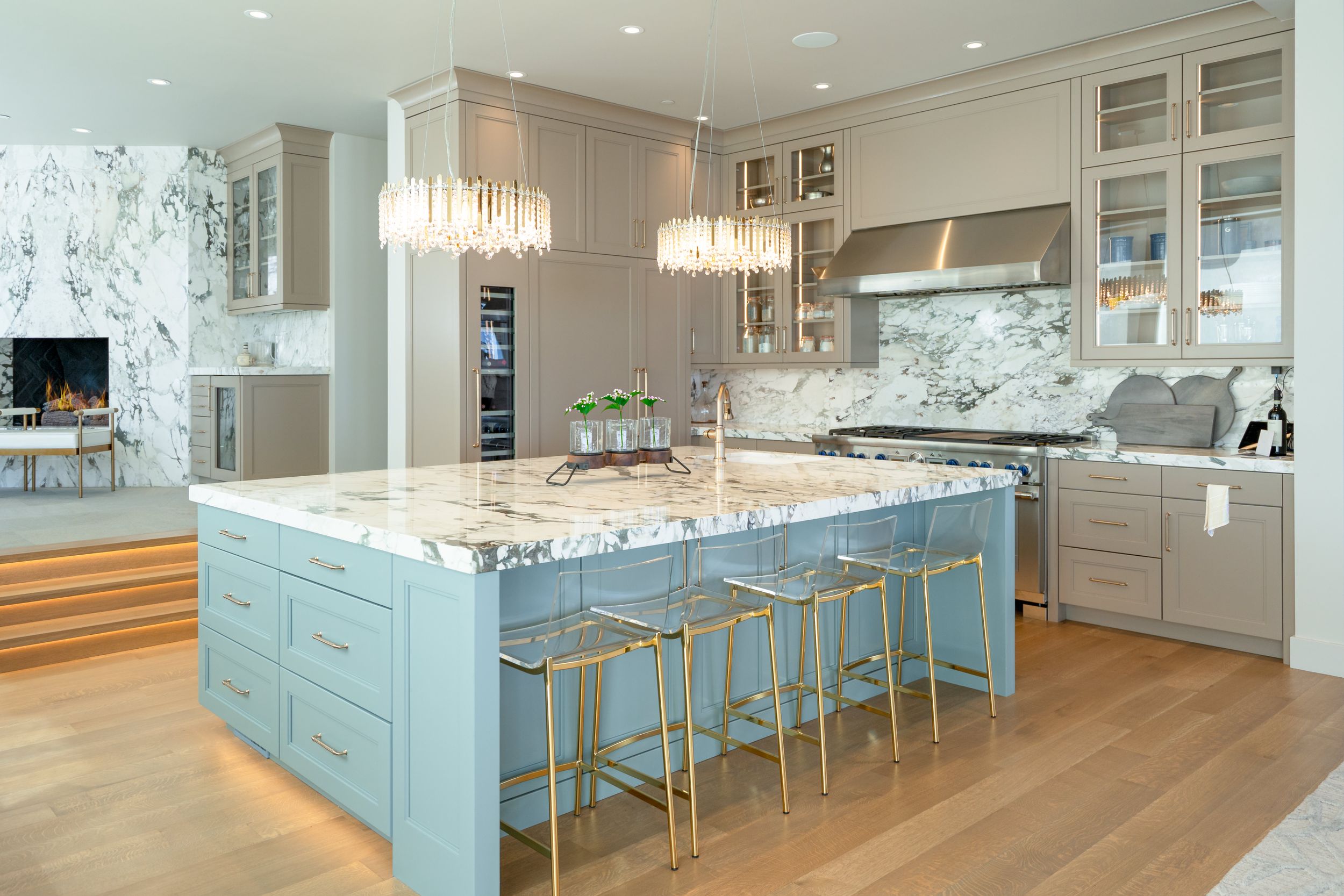 Modern kitchen featuring a large island with marble countertop and light blue cabinetry.